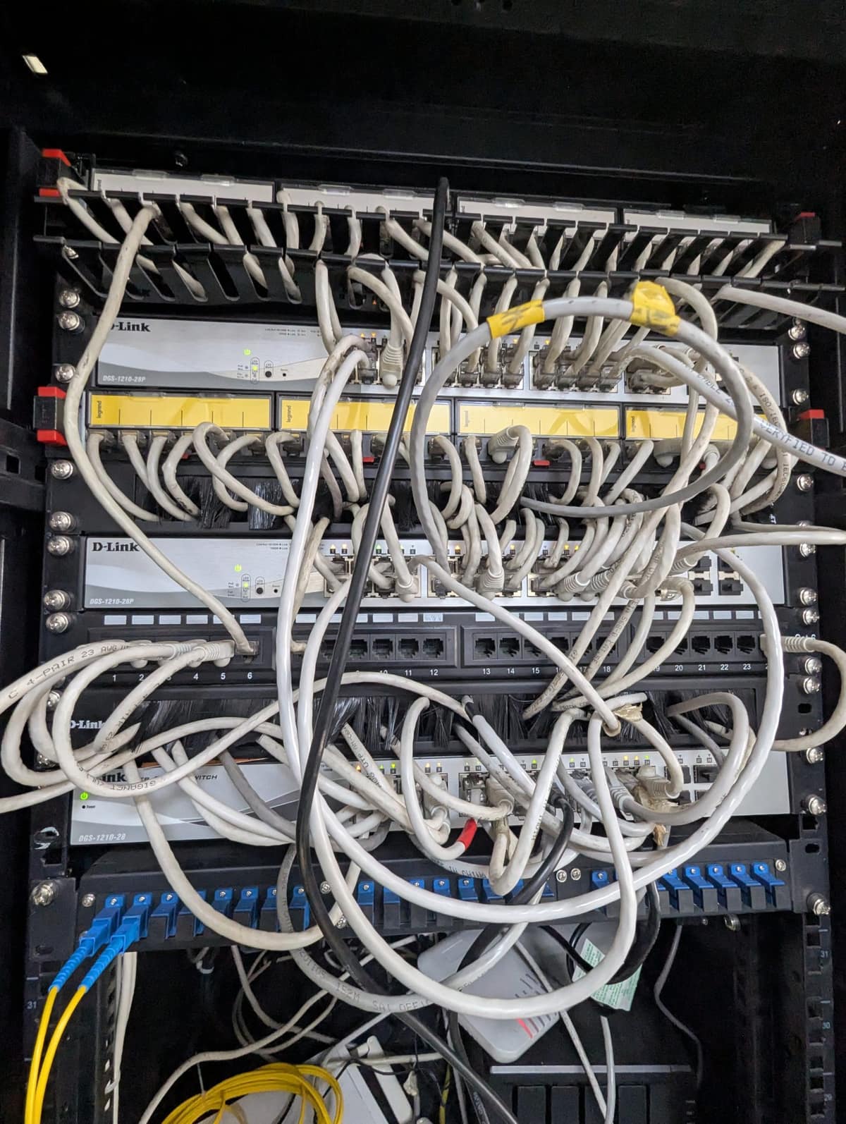 A tangle of network cables in an office comms cabinet.